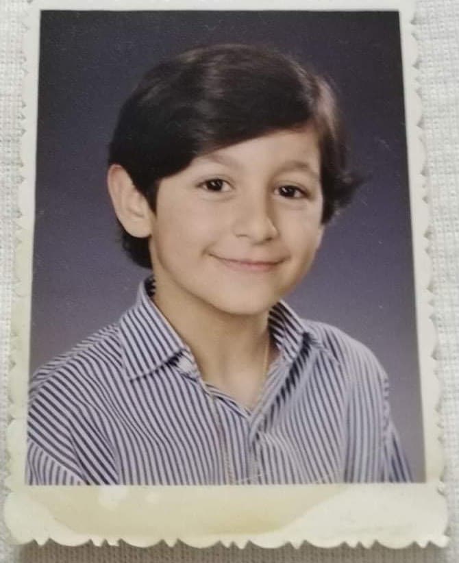 Markus Istafanous as a child, school portrait in a striped shirt